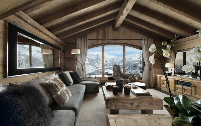 matériaux naturels, décoration murale en bois, poutres au plafond, meubles en bois et coussins en peau et fourrure