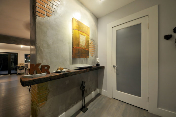 Les murs du couloir sont finis avec de la maçonnerie et de la masse à la spatule