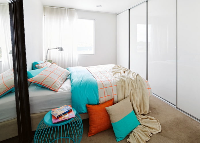 Lit en face d'une armoire aux portes brillantes