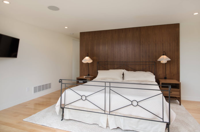un lit en fer forgé dans une chambre de style moderne