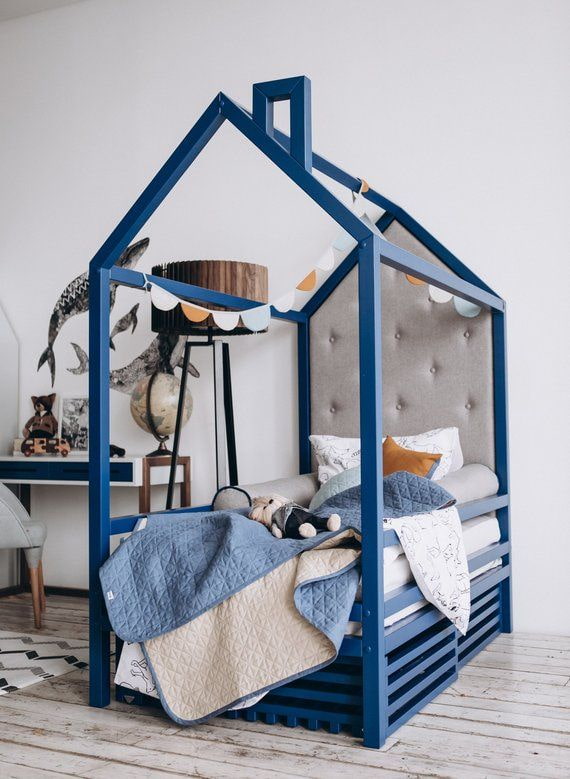 lit bleu en forme de maison dans une chambre d'enfant