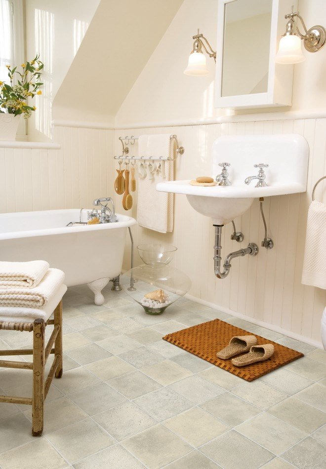 Carrelage de vinyle de quartz sous du carrelage en porcelaine dans la salle de bain
