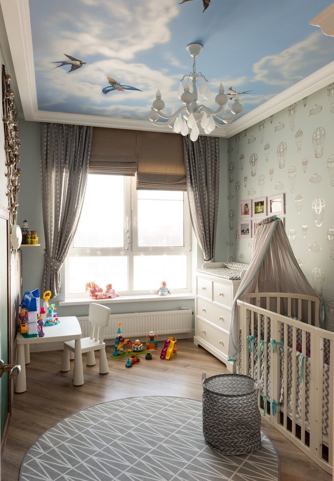 Plafond tendu avec un lustre dans la chambre de bébé