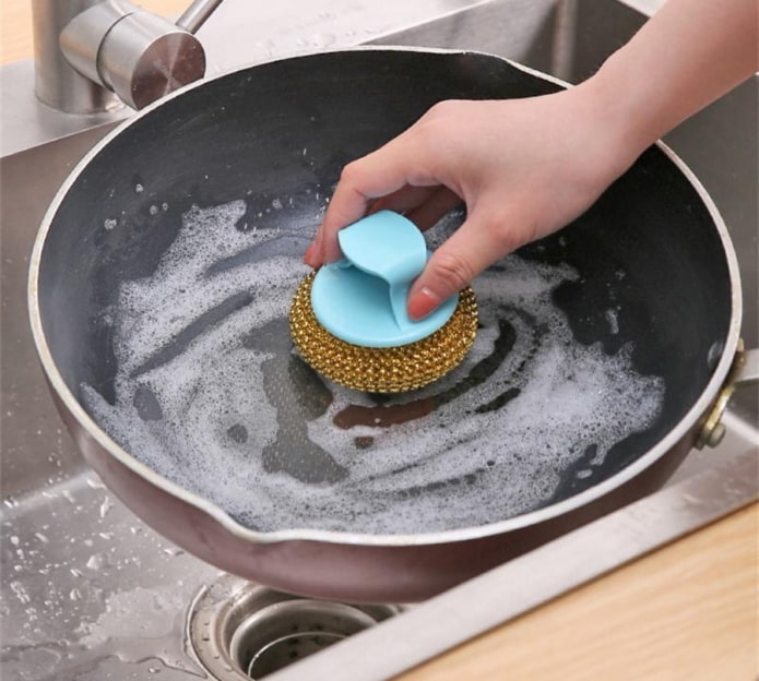 nettoyer une poêle à frire avec une éponge dure