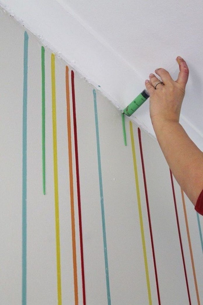 application de gouttes de peinture sur le mur avec une seringue