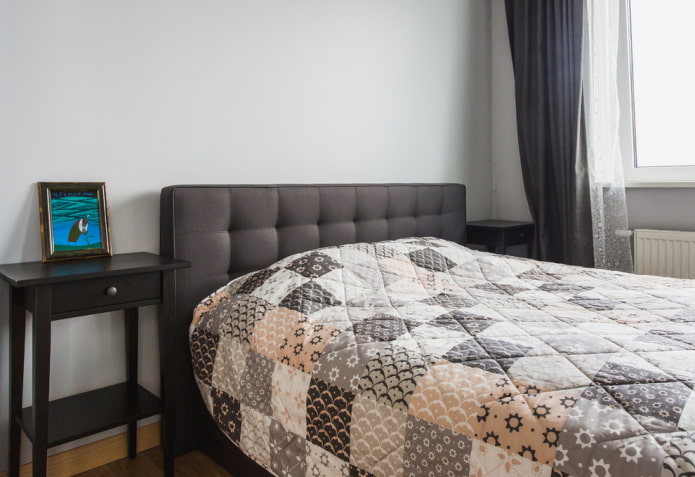 Lit avec un couvre-lit matelassé dans la chambre