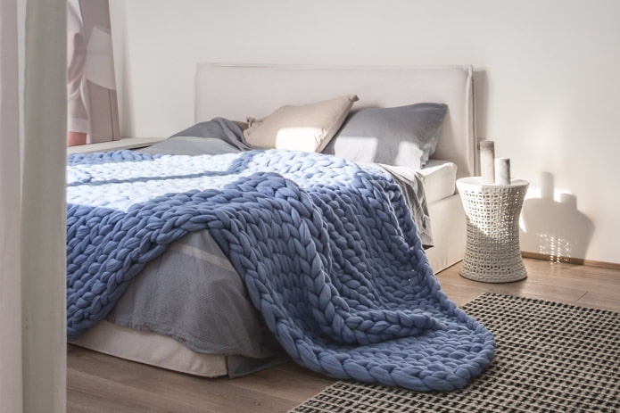 lit avec un grand couvre-lit tricoté dans la chambre