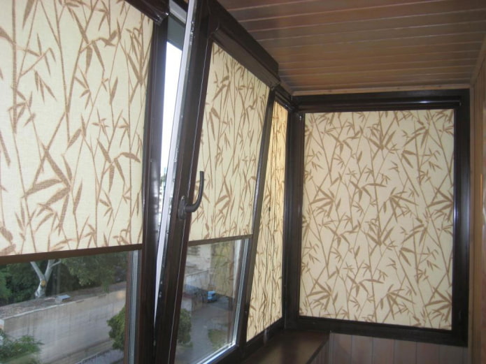 stores enrouleurs beiges à motifs sur la loggia