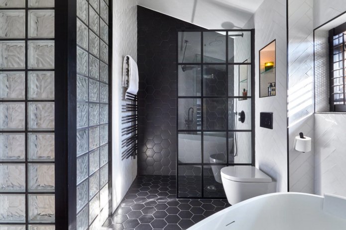 Murs et cloisons en briques de verre dans une salle de bain monochrome