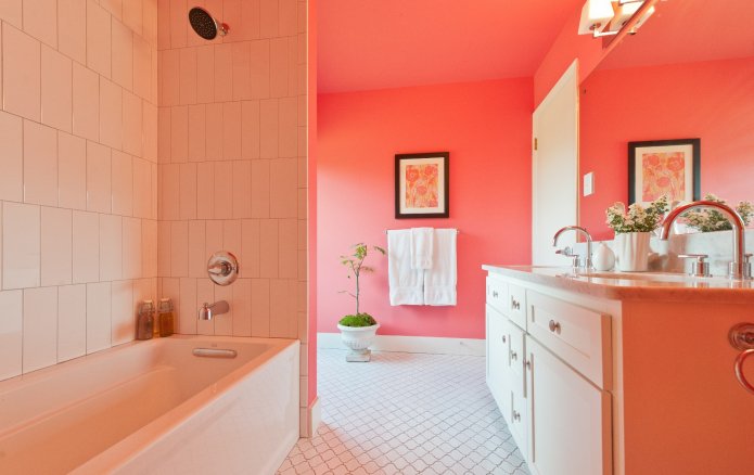 Murs peints corail et carrelage blanc dans la salle de bain