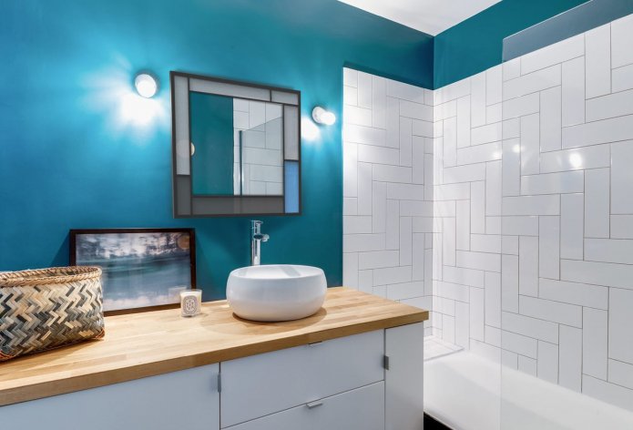 Murs peints turquoise foncé et carrelage blanc dans la salle de bain