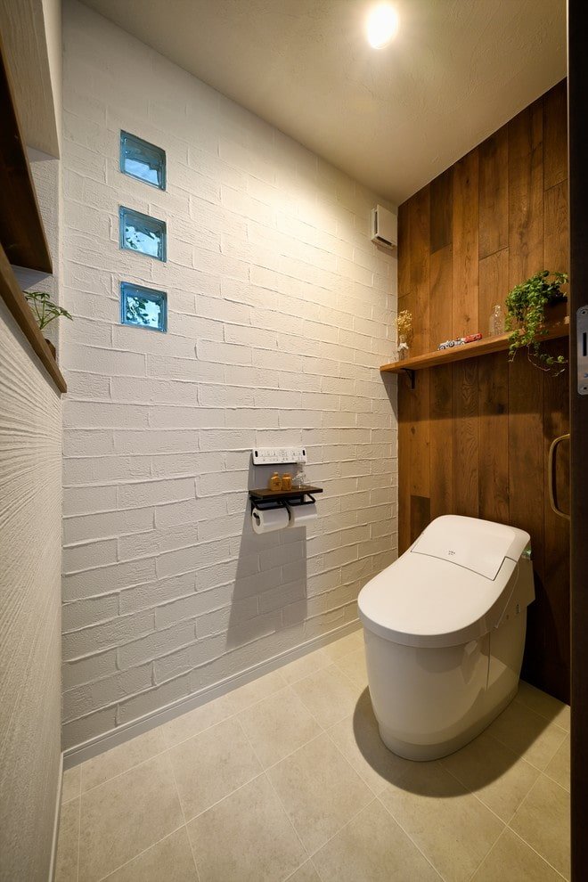 Toilettes blanches avec faux mur en bois