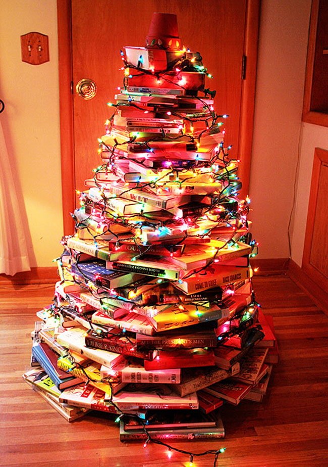 Sapin de Noël fait de livres avec guirlandes