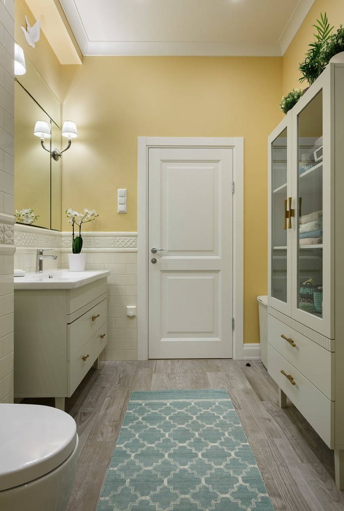 Salle de bain avec murs jaune pâle et meubles blancs